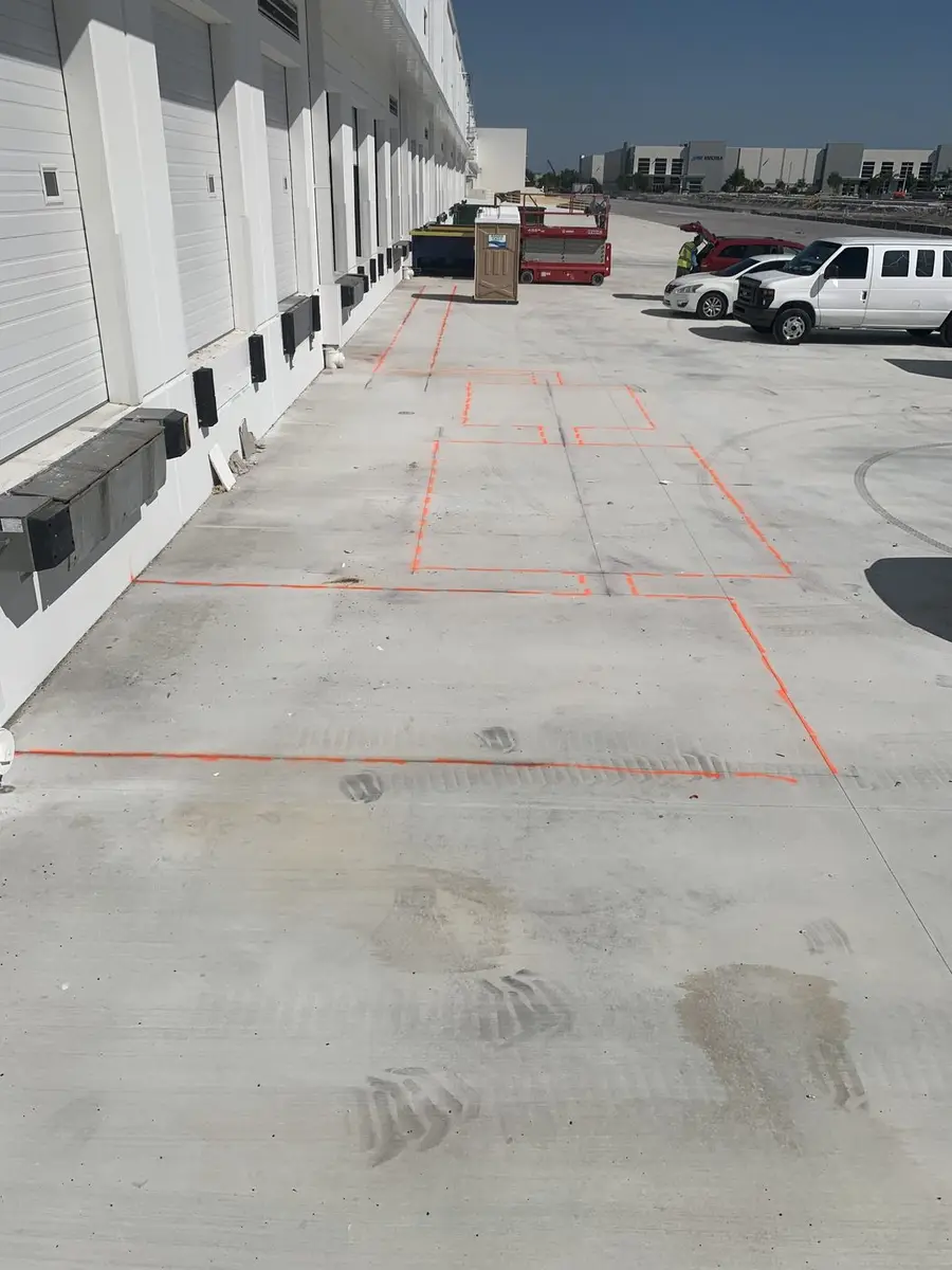 Commercial plaza unit with the plumbing layout marked out in paint across the slab