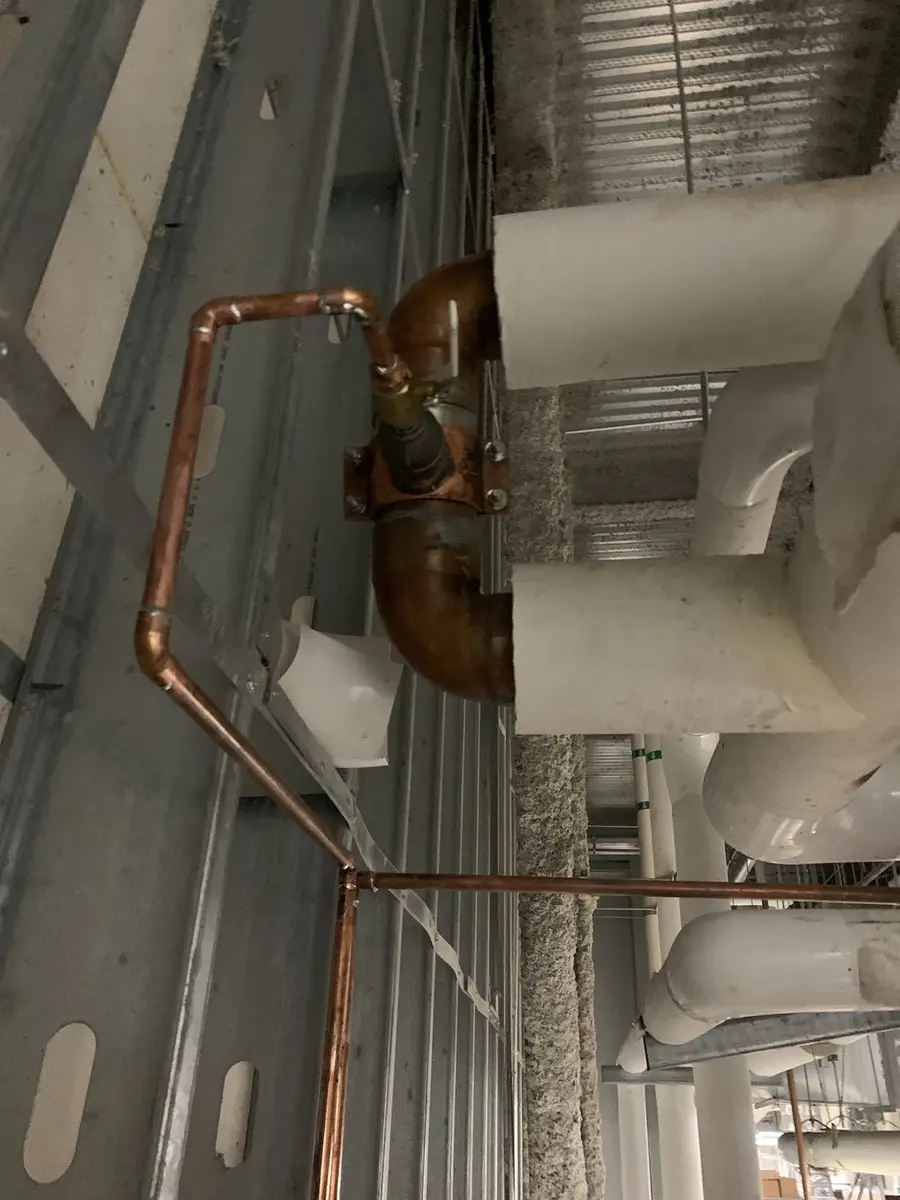 Copper riser turned out of a mechanical shaft ceiling and dropped to serve the floor below