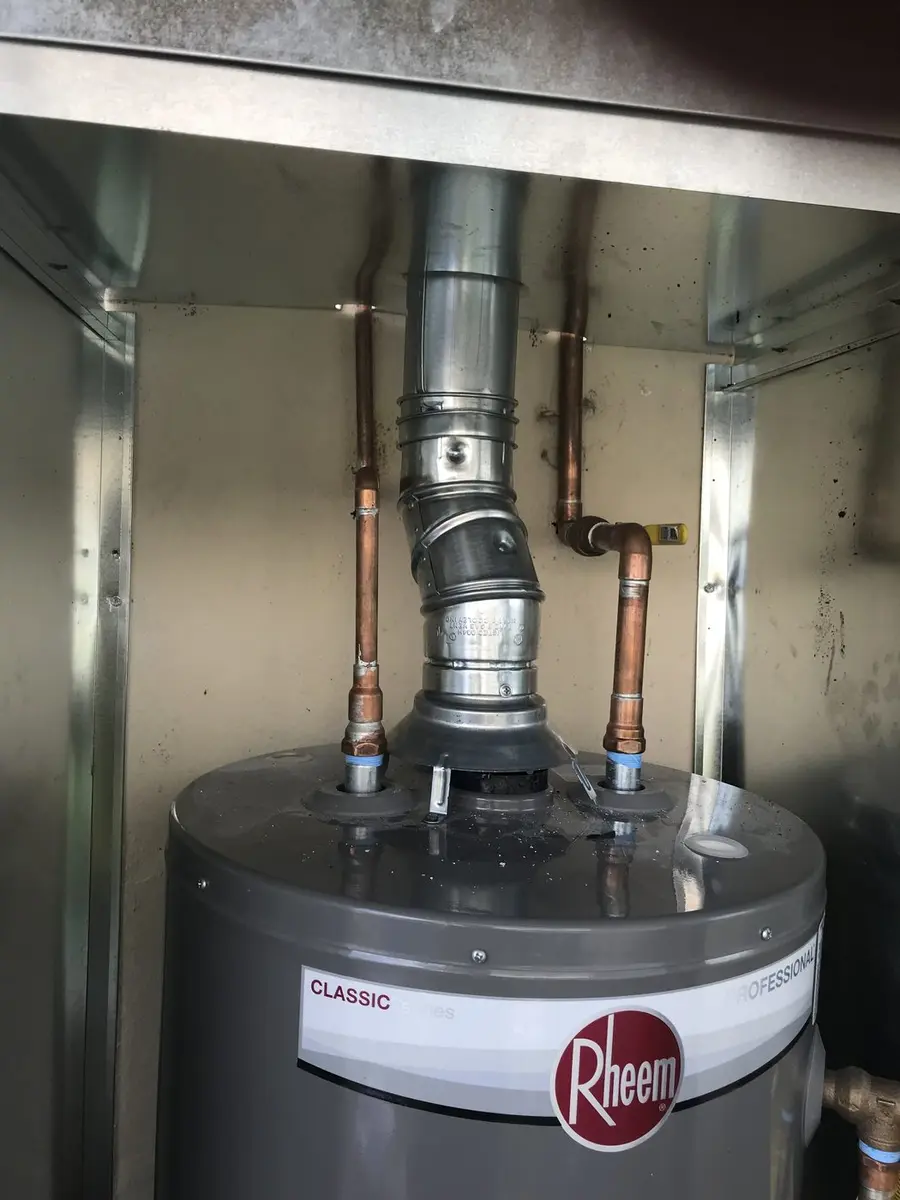 A gas storage water heater with its new draft hood and flue vent connected above it