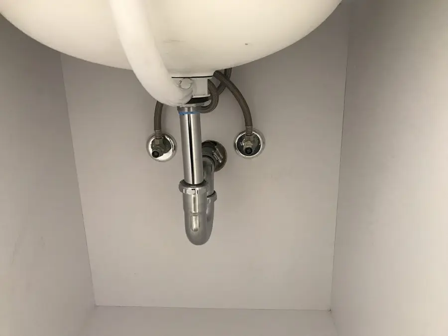 Chrome P-trap and angle stops fitted neatly beneath a wall-hung lavatory