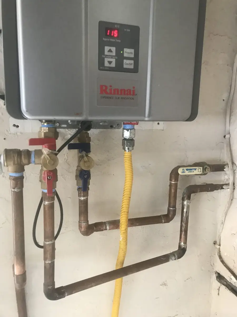 Wall-mounted tankless water heater with new copper hot and cold lines, isolation valves and a yellow gas connection