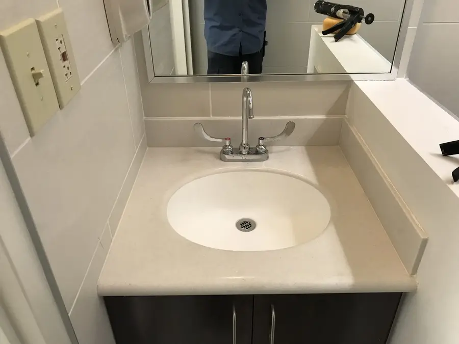 Newly installed undermount vanity basin with a chrome faucet set and mirror above