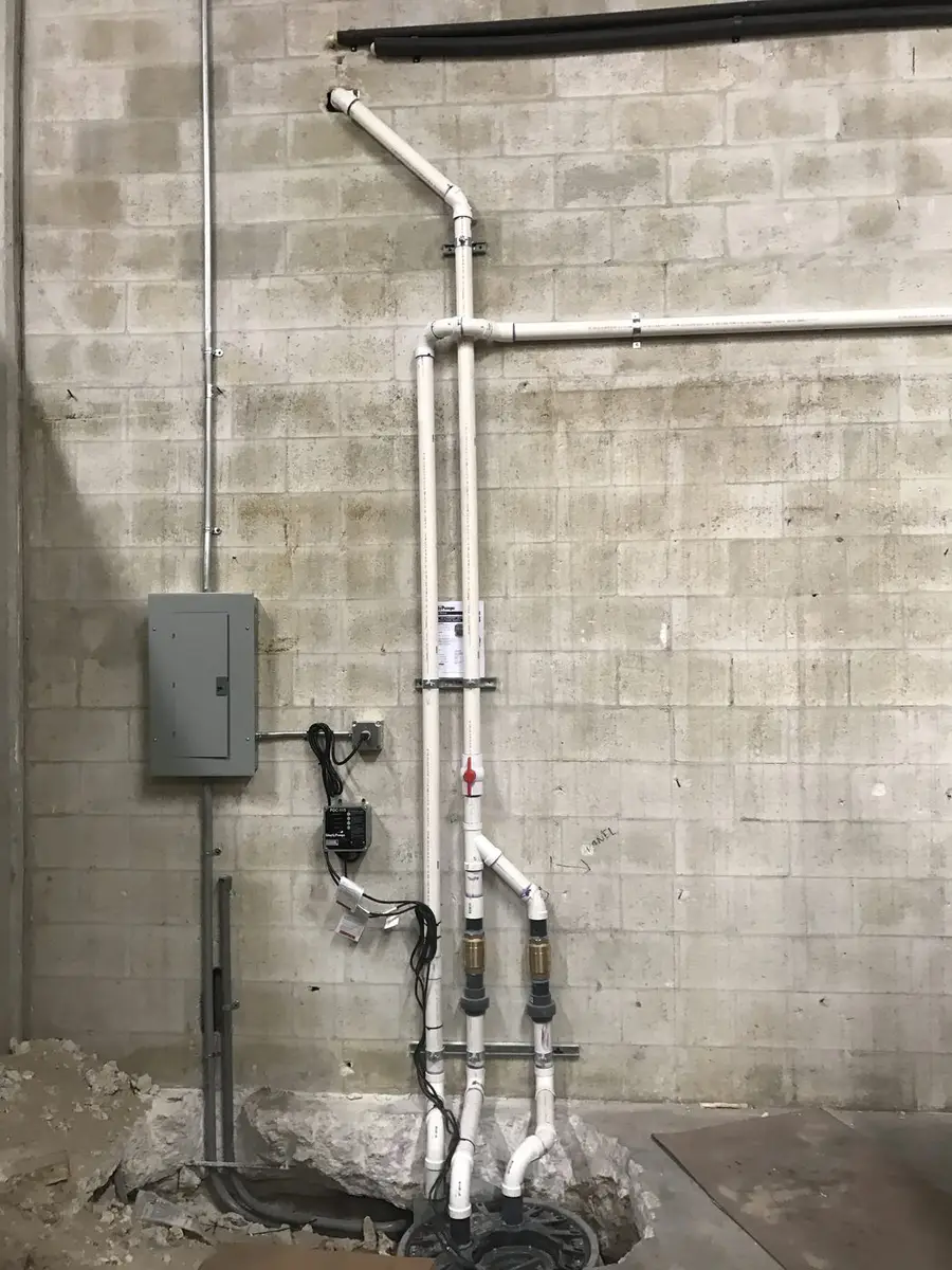 Water heater rough-in against a block wall with the supply lines, drain and electrical disconnect set